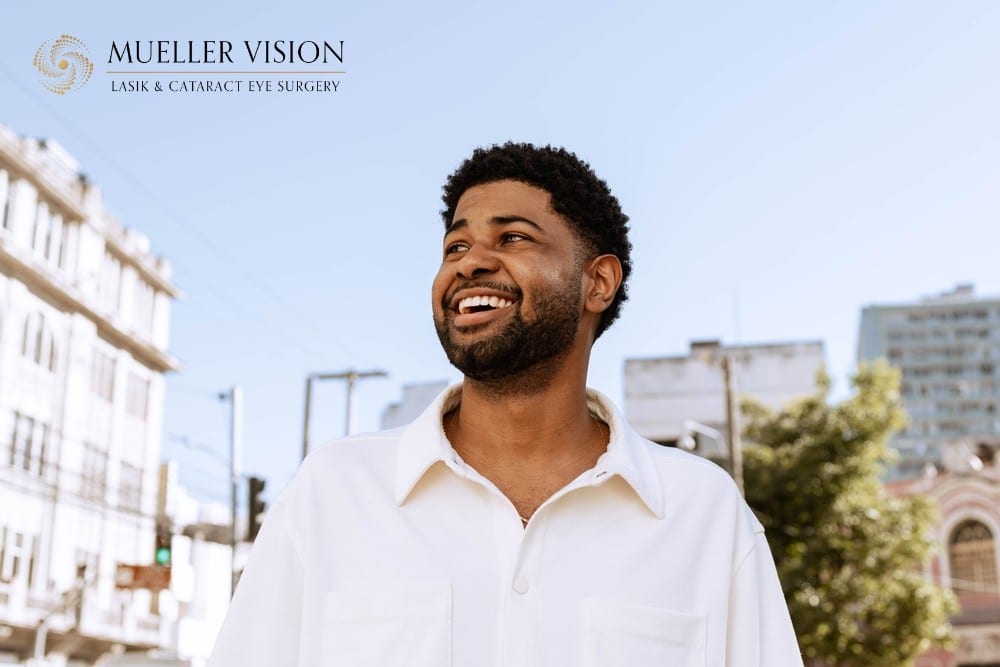 Smiling man outdoors with the Mueller Vision logo